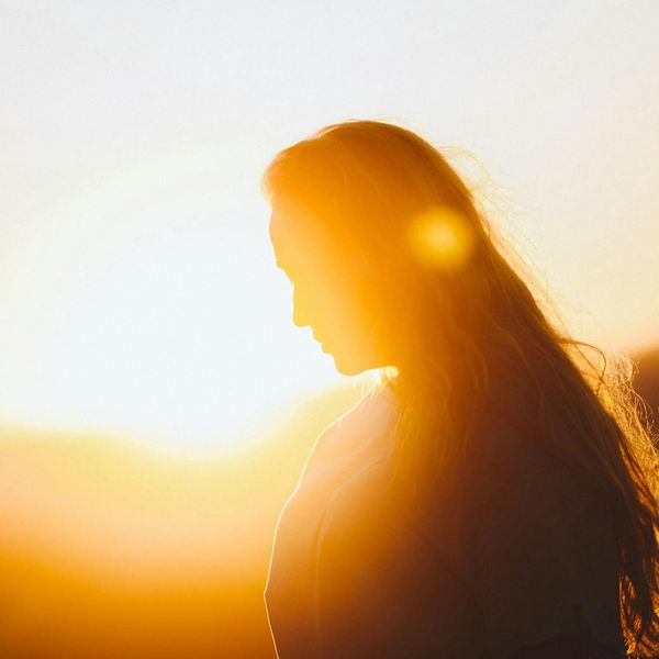 Woman feeling energized and calm with golden light accents around her.